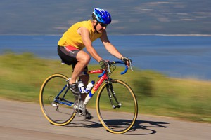Male road cyclist with Okanagan Lake in the background, Adventure Bay, Vernon, British Columbia, Canada.